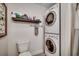 A compact laundry area featuring a stacked washer and dryer and a shelf for storage at 1411 Powhaton Dr., Myrtle Beach, SC 29577