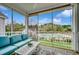 A cozy screened-in porch featuring a blue couch, a white table, and a view of the community pool at 1411 Powhaton Dr., Myrtle Beach, SC 29577