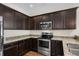 Modern kitchen with dark cabinetry, granite countertops, and stainless steel appliances at 159 Terracina Circle, Myrtle Beach, SC 29588