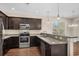 Updated kitchen with stainless steel appliances, granite countertops, and dark wood cabinets at 159 Terracina Circle, Myrtle Beach, SC 29588