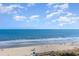 Picturesque beach view with clear blue water, sandy shores, and scattered beachgoers enjoying the sunny day at 161 Seawatch Dr. # 808, Myrtle Beach, SC 29572