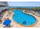 A large outdoor pool area with people swimming and sunbathing, with the ocean visible in the background at 161 Seawatch Dr. # 808, Myrtle Beach, SC 29572
