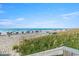 Beautiful beach view with blue skies, ocean, and beach umbrellas in the distance at 1625 S Ocean Blvd. # 802, North Myrtle Beach, SC 29582