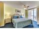 Relax in this cozy bedroom featuring a ceiling fan, sliding doors to the balcony, and beautiful blue bedding at 1625 S Ocean Blvd. # 802, North Myrtle Beach, SC 29582