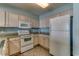 An efficient kitchen featuring granite counters, white appliances, and tile floors at 1625 S Ocean Blvd. # 802, North Myrtle Beach, SC 29582