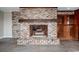 A close-up of a brick fireplace with a rustic wood mantel and hearth at 201 River Rd., Georgetown, SC 29440