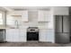 Kitchen features white cabinets, brick floors, and stainless appliances at 201 River Rd., Georgetown, SC 29440