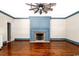 Spacious living room features a blue accent fireplace and lovely hardwood floors at 201 River Rd., Georgetown, SC 29440