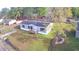 An aerial view of a gray home with a black roof surrounded by green yard and trees with other homes nearby at 2016 Misty Morning Dr., Conway, SC 29527