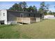 Backyard view of a single-story home featuring a wooden deck and well-maintained lawn at 2016 Misty Morning Dr., Conway, SC 29527