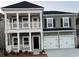 Charming two-story home featuring a double garage and inviting front porch with white pillars and a balcony at 2017 Lone Cypress Dr, Myrtle Beach, SC 29579