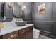 Stylish powder room with a vessel sink, elegant fixtures, and decorative wall paneling at 208 Wahee Pl., Conway, SC 29527
