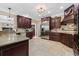 Well-equipped kitchen featuring dark wood cabinets, granite countertops, stainless steel appliances, and tile flooring at 208 Wahee Pl., Conway, SC 29527