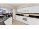 Bright kitchen featuring white cabinets, black countertops, and an opening to the living area at 2151 Bridge View Ct. # 1-1103, North Myrtle Beach, SC 29582