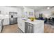A modern kitchen with white cabinetry, quartz countertops, a stainless steel refrigerator, and an adjacent seating area at 308 Golan Circle # A, Myrtle Beach, SC 29579