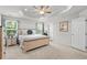 Main bedroom with carpet, tray ceiling, a light wood bed frame, neutral decor, and bright natural light from the window at 308 Golan Circle # A, Myrtle Beach, SC 29579