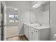 Bathroom featuring dual sinks, white cabinets, and views into the bedroom at 308 Mayflower Dr., Calabash, NC 28467