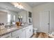 Bathroom with a granite-topped vanity, dual sinks, and ample cabinet space for storage at 308 Mayflower Dr., Calabash, NC 28467