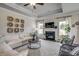 Bright living room featuring a fireplace, coffered ceilings, and stylish decor with natural light from large windows at 308 Mayflower Dr., Calabash, NC 28467