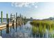 View of the waterfront, featuring a boat dock and lush green landscape at 308 Mayflower Dr., Calabash, NC 28467