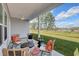 Cozy back patio with wicker chairs, offering beautiful views of the lush green lawn and trees at 312 Mayflower Dr., Calabash, NC 28467
