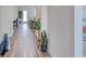 Well-lit hallway with wood-look flooring and decorative houseplants at 312 Mayflower Dr., Calabash, NC 28467