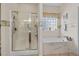 Bright bathroom featuring walk-in shower, soaking tub and window with privacy glass at 387 Foxtail Dr., Longs, SC 29568