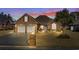 Charming brick home features a two-car garage, well-maintained lawn, and beautiful landscaping under a colorful sky at 387 Foxtail Dr., Longs, SC 29568