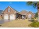 Beautiful brick home with a two car garage, manicured lawn and lush landscaping at 387 Foxtail Dr., Longs, SC 29568