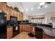 A kitchen features dark appliances, light brown cabinets, and a vaulted ceiling at 387 Foxtail Dr., Longs, SC 29568