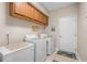 Bright laundry room with upper cabinets and white washer and dryer at 387 Foxtail Dr., Longs, SC 29568