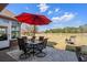 A patio with a table, chairs, and a red umbrella faces a golf course at 387 Foxtail Dr., Longs, SC 29568