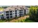 A modern, multi-story apartment building with screened-in porches, surrounded by trees at 395 S Crow Creek Dr. # 1704, Calabash, NC 28467