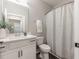 Well-lit bathroom with a white vanity, mirror, shower with curtain, and modern fixtures at 395 S Crow Creek Dr. # 1704, Calabash, NC 28467