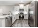Bright kitchen with stainless steel appliances, white cabinets, and hardwood flooring at 395 S Crow Creek Dr. # 1704, Calabash, NC 28467