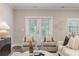 Bright living room featuring gray accent chairs and stylish decor, with natural light through patio doors at 395 S Crow Creek Dr. # 1704, Calabash, NC 28467