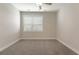 This is a bedroom with neutral walls and carpet and a window with wood trim at 395 S Crow Creek Dr. # 1709, Calabash, NC 28467