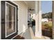 Covered porch with an outdoor seating area beyond the glass paneled front door at 395 S Crow Creek Dr. # 1710, Calabash, NC 28467
