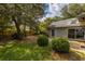 Landscaped backyard featuring shrubs, trees, and a concrete patio adjacent to the brick home at 409 65Th Ave. N, Myrtle Beach, SC 29572