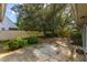 Backyard featuring trees, shrubs, and concrete patio, enclosed by a tan privacy fence at 409 65Th Ave. N, Myrtle Beach, SC 29572