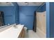 Bright blue bathroom featuring a vanity, shower with curtain, and white tile flooring at 409 65Th Ave. N, Myrtle Beach, SC 29572