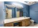 Blue bathroom with a large mirror, white countertop vanity, and view of the shower-tub combo at 409 65Th Ave. N, Myrtle Beach, SC 29572