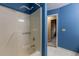 Blue tiled bathroom featuring a shower-tub with shower curtain and neutral hallway beyond at 409 65Th Ave. N, Myrtle Beach, SC 29572