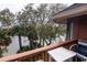 A relaxing balcony with a small table overlooks water and tropical trees and foliage at 410 Melrose Pl. # 308, Myrtle Beach, SC 29572