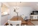 Comfortable dining area with rustic wood table, white chairs, and convenient pass-through to kitchen at 410 Melrose Pl. # 308, Myrtle Beach, SC 29572