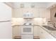 Bright kitchen featuring white cabinets, granite countertops, and stainless sink at 410 Melrose Pl. # 308, Myrtle Beach, SC 29572