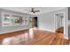 Bright living room with hardwood floors, large windows, modern ceiling fan, and a view of the front yard at 4320 Stevens St., Loris, SC 29569