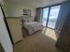 Bright bedroom featuring a queen bed, balcony access, and ocean views for a relaxing getaway at 4719 S Ocean Blvd. # 209, North Myrtle Beach, SC 29582