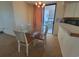 Dining area with a glass table, seating for four, and access to a balcony with ocean views at 4719 S Ocean Blvd. # 209, North Myrtle Beach, SC 29582