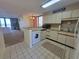Well-maintained kitchen with white cabinets, washer, dryer, microwave, and tile floors at 4719 S Ocean Blvd. # 209, North Myrtle Beach, SC 29582
